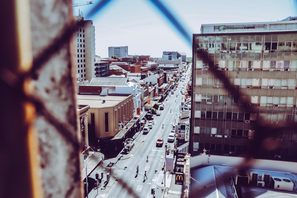 Photographie en plongée d’un immeuble de grande hauteur et d’une route de la ville pendant la journée