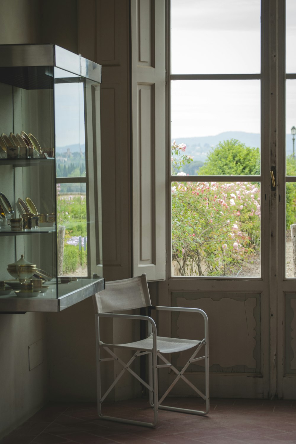 창문과 진열장 근처의 빈 흰색 접이식 의자