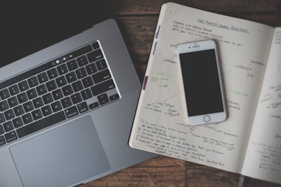 Close-up of a notebook with business notes and a laptop on a blue azure desk.