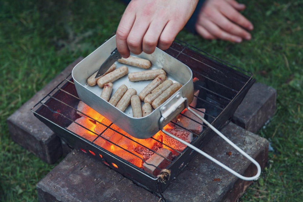 Pfanne mit rohen Würstchen auf dem Grill