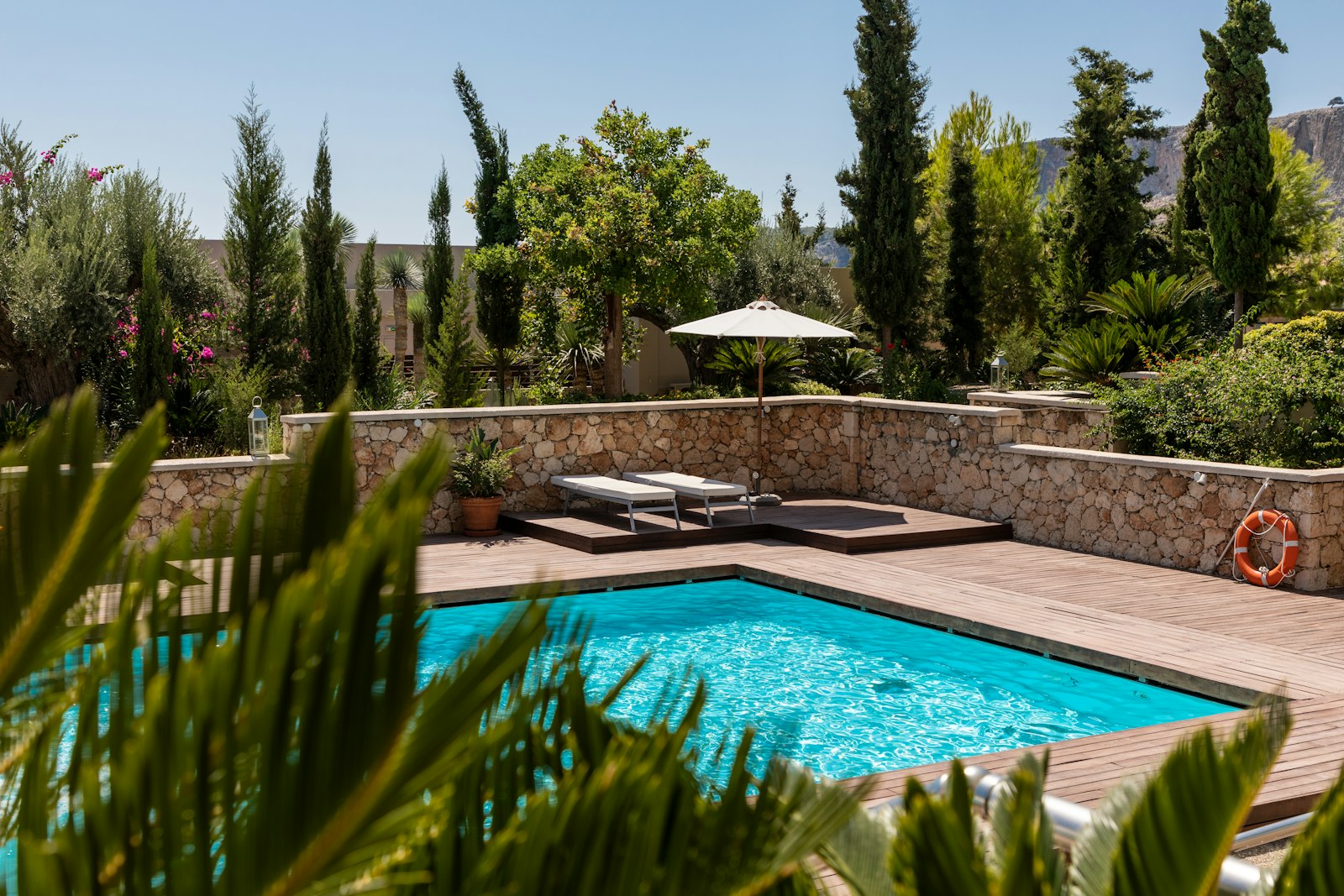 A clean, clear backyard swimming pool maintained by Clear Water Pools