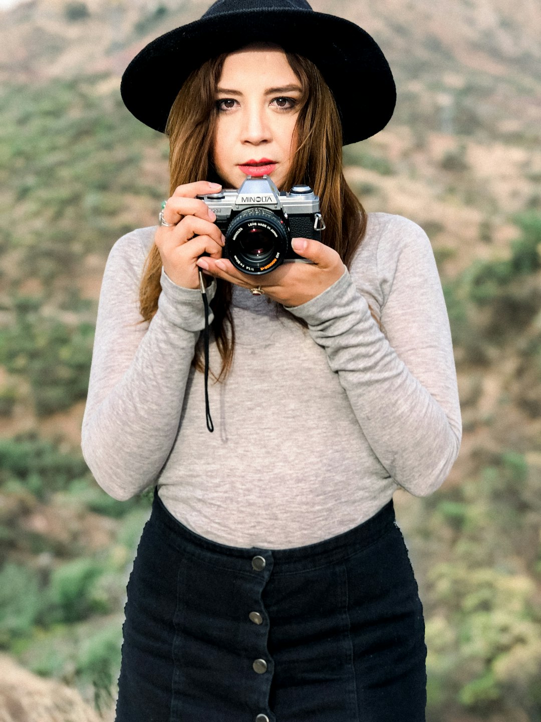 selective focus photo of woman holding gray and black Milton digital camera