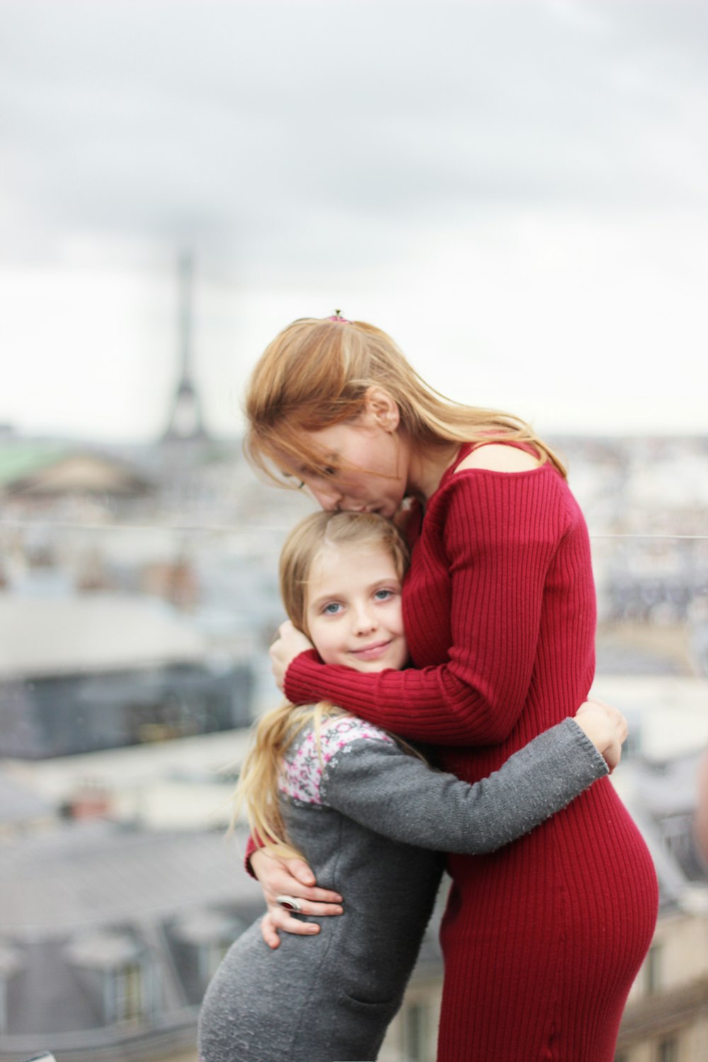 woman kissing girl's head