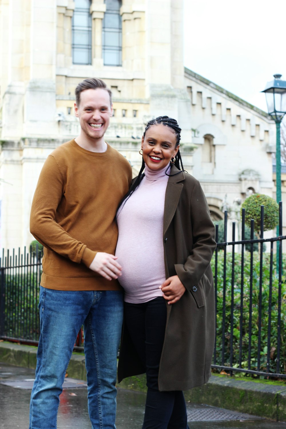 pregnant woman beside man standing on the concrete pavement
