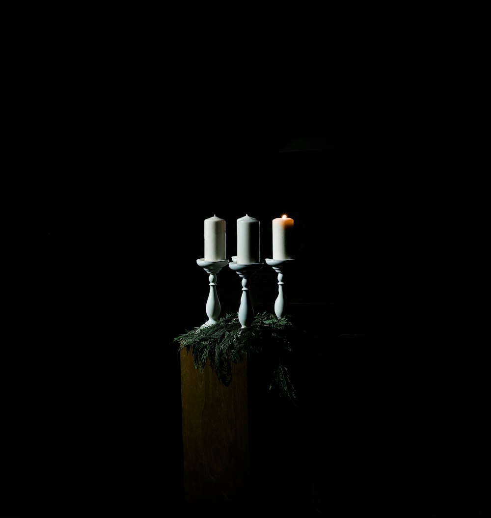 low-light photo of white pillar candles