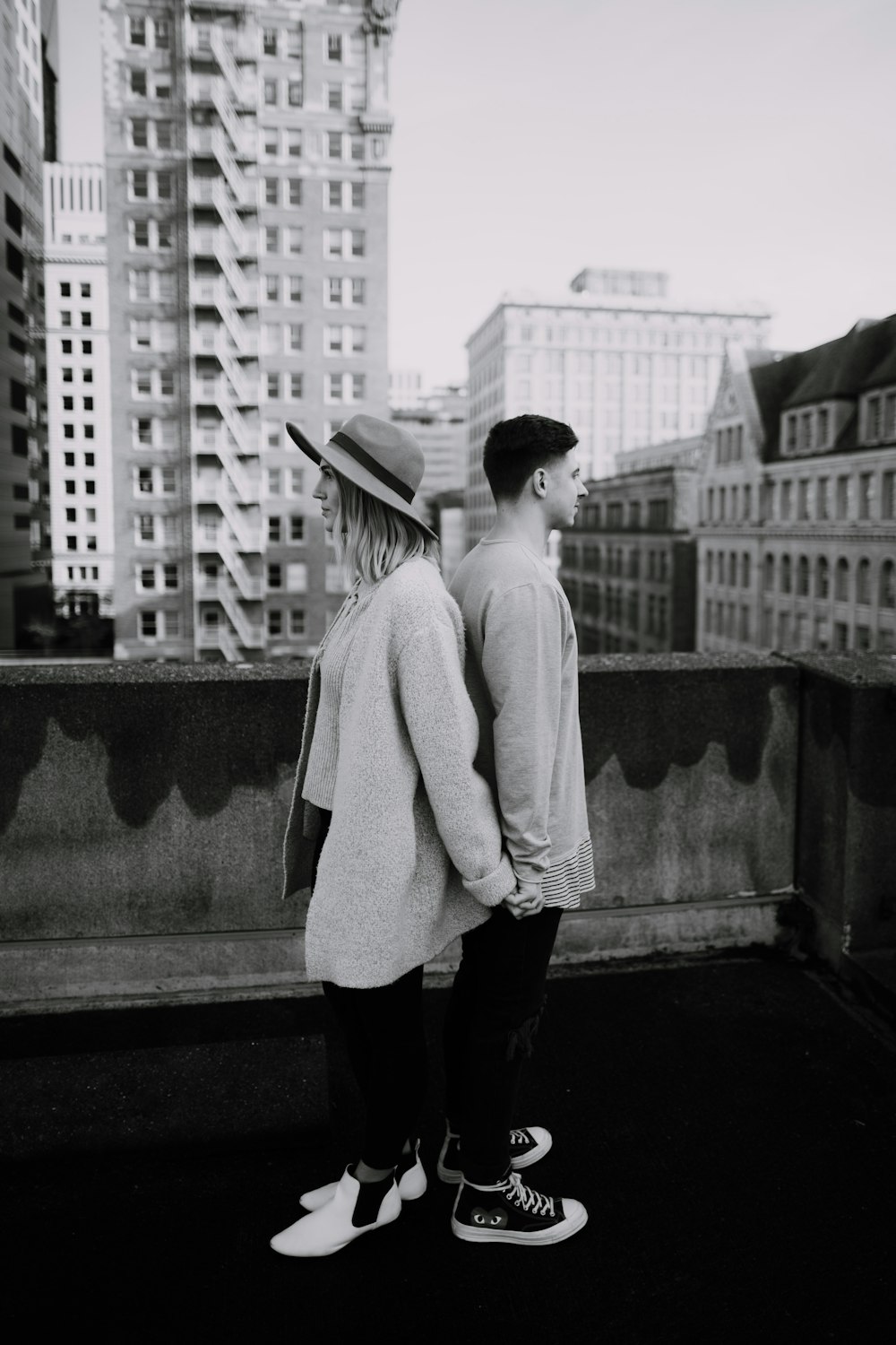 grayscale photography of standing man and woman near outdoor during daytime