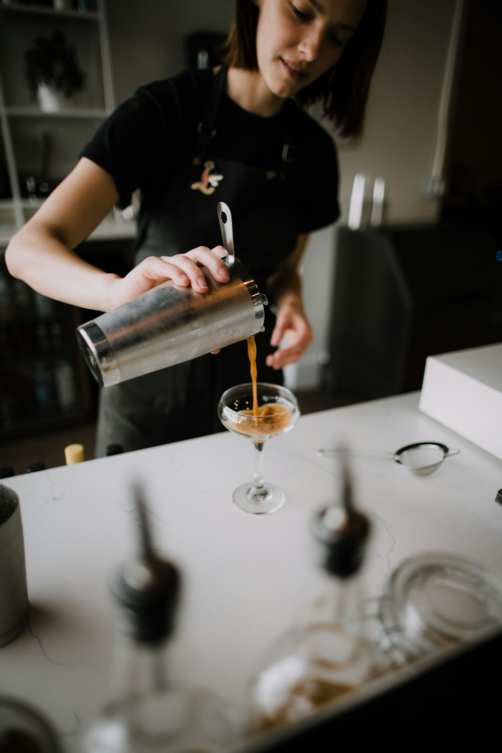 woman pouring liquid on margarita glass