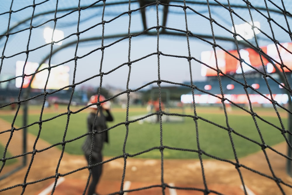 Una vista de un campo de béisbol a través de una red