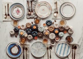 A cozy autumn table setup featuring warm-toned placemats and elegant ceramic dishes.