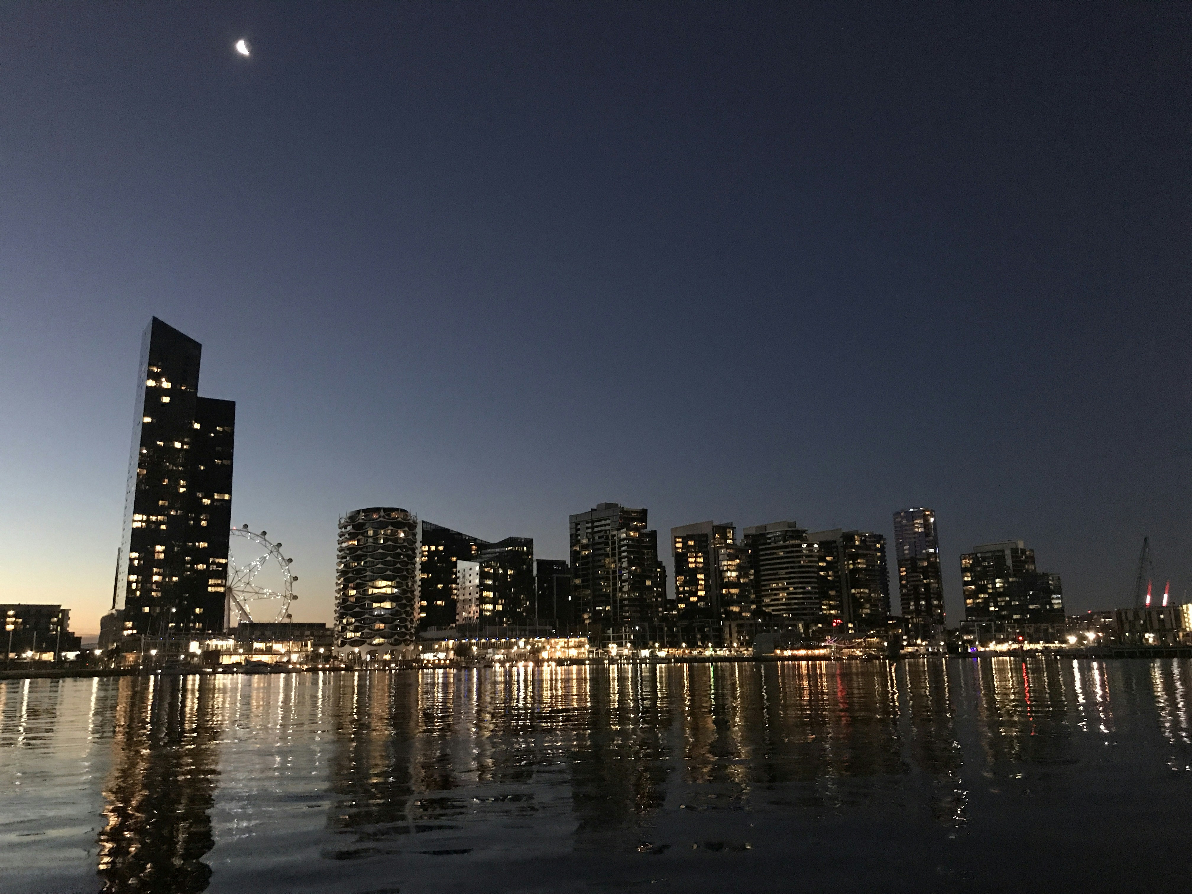 architectural photography of lighted city buildings near body of water