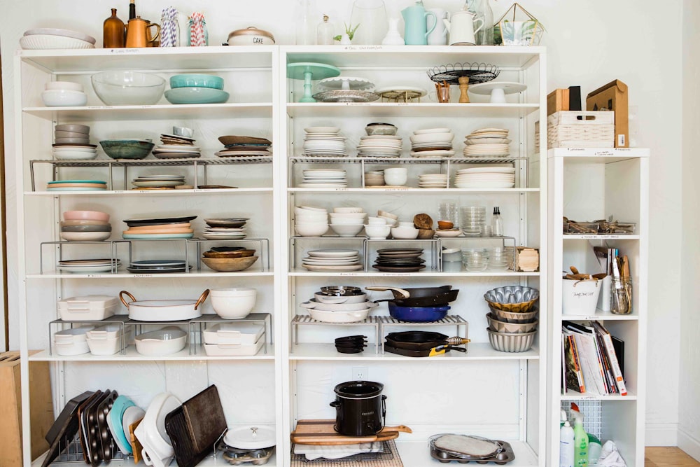 assorted ceramic dinnerware set displayed in white wooden shelf