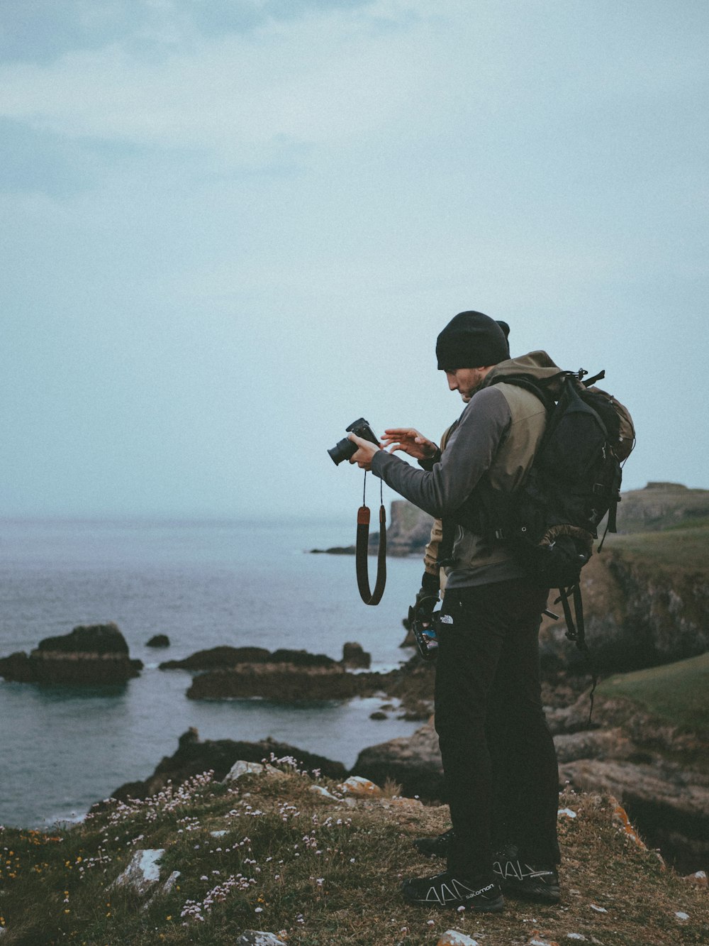 shallow focus photo of man in gray hoodie holding camera