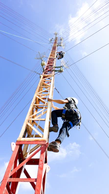 person climbing in electricity tower