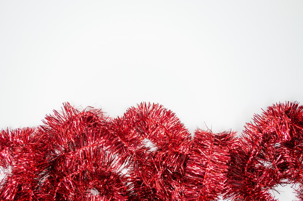 a bunch of red tinsel next to a white wall