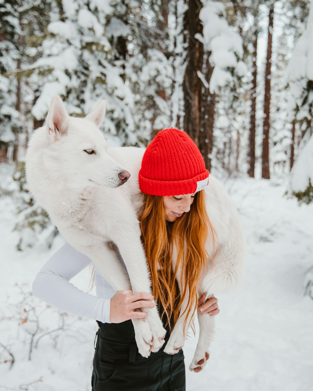 woman lifting white dog