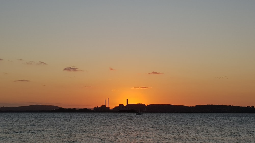 the sun is setting over a large body of water