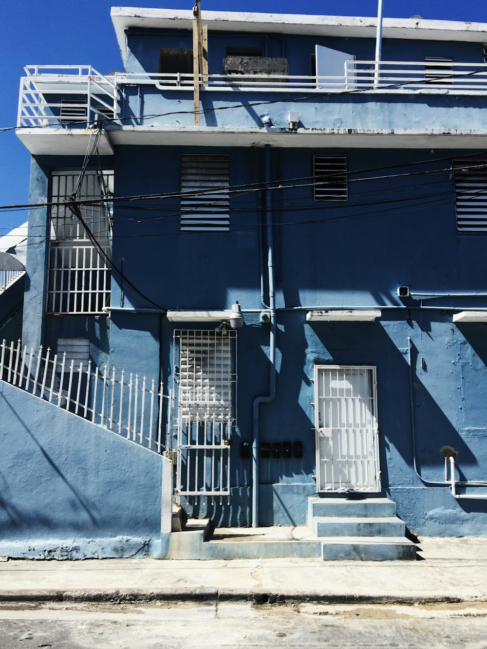 a blue building with white balconies and a white door