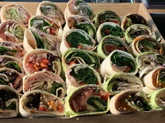 An array of homemade vegetarian wraps with fresh ingredients.