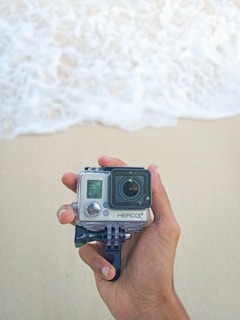 Vlogger filming with an Insta360 camera on a sunny beach in Santa Catarina.