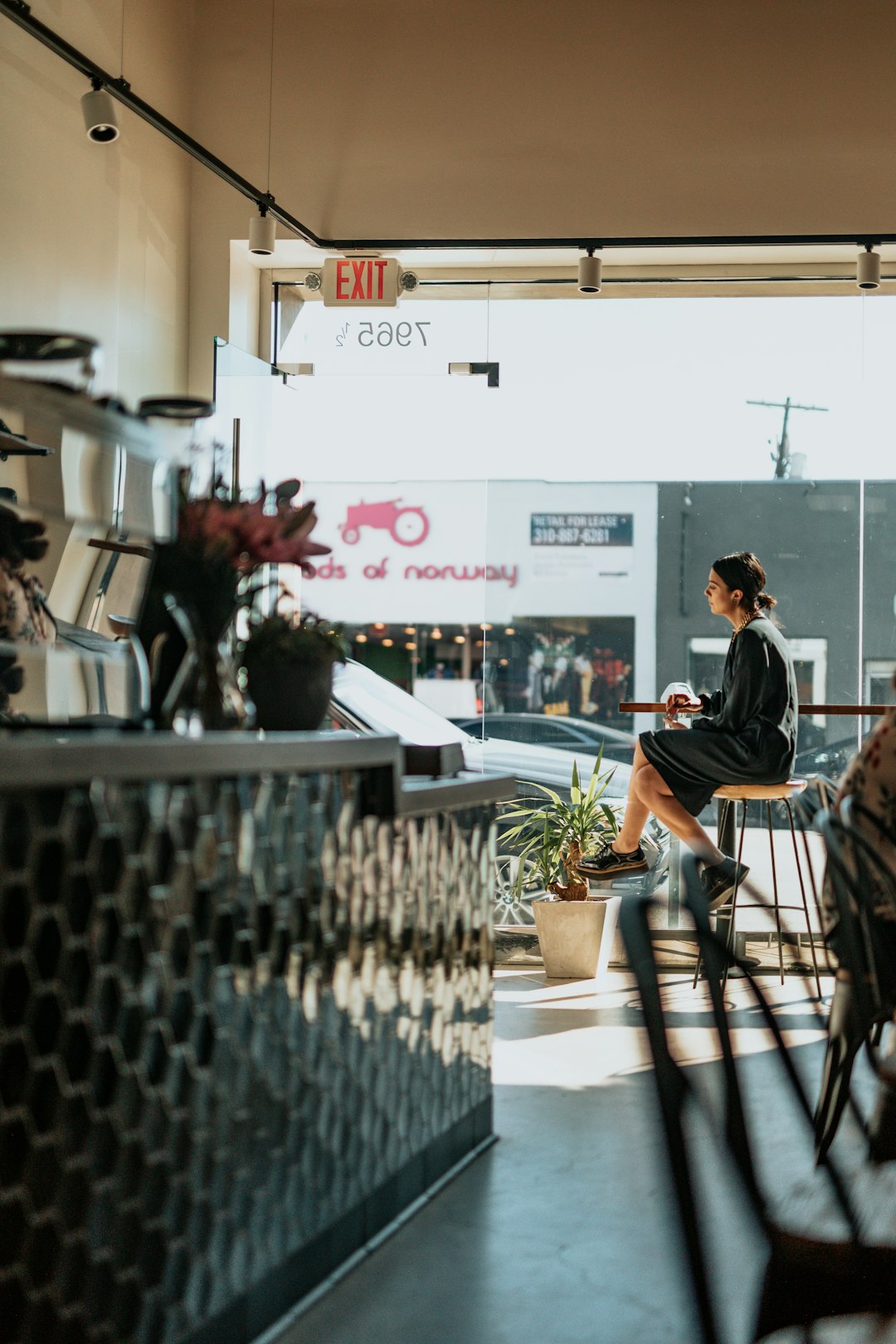 woman sitting on brown bar stool outdoors