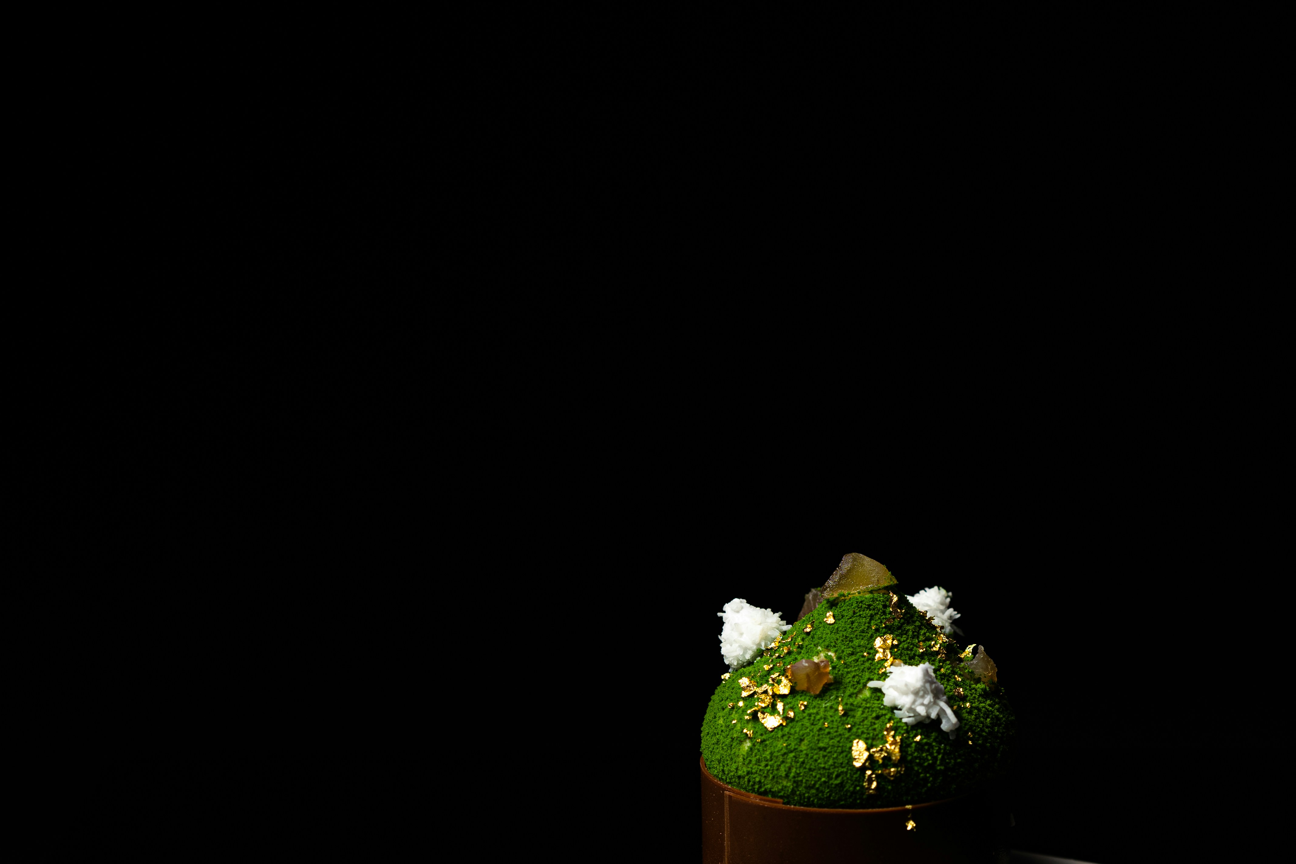 a green cake sitting on top of a wooden table