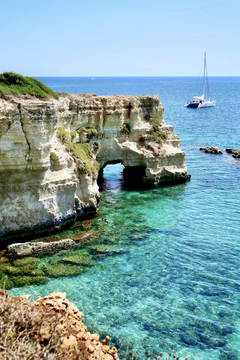 Arco naturale e barca a vela a Torre Sant'Andrea