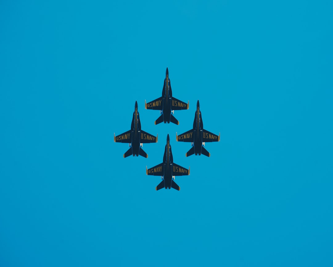 four grey jetplanes under blue sky