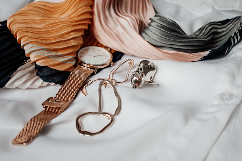 round white and gold-colored analog watch with gold-colored milanese band