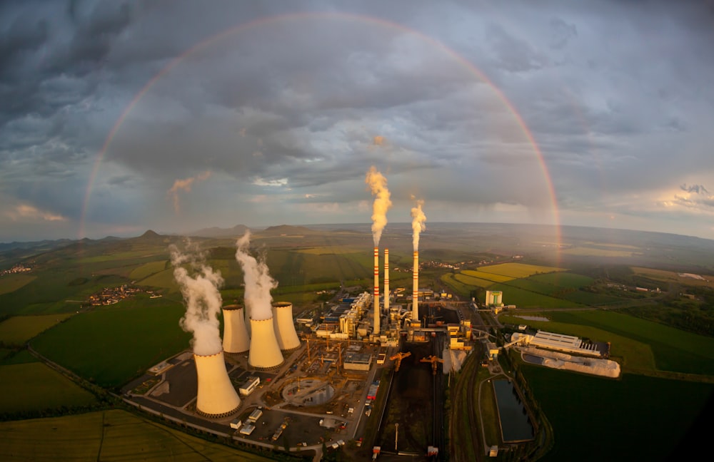 a large factory with a rainbow in the background