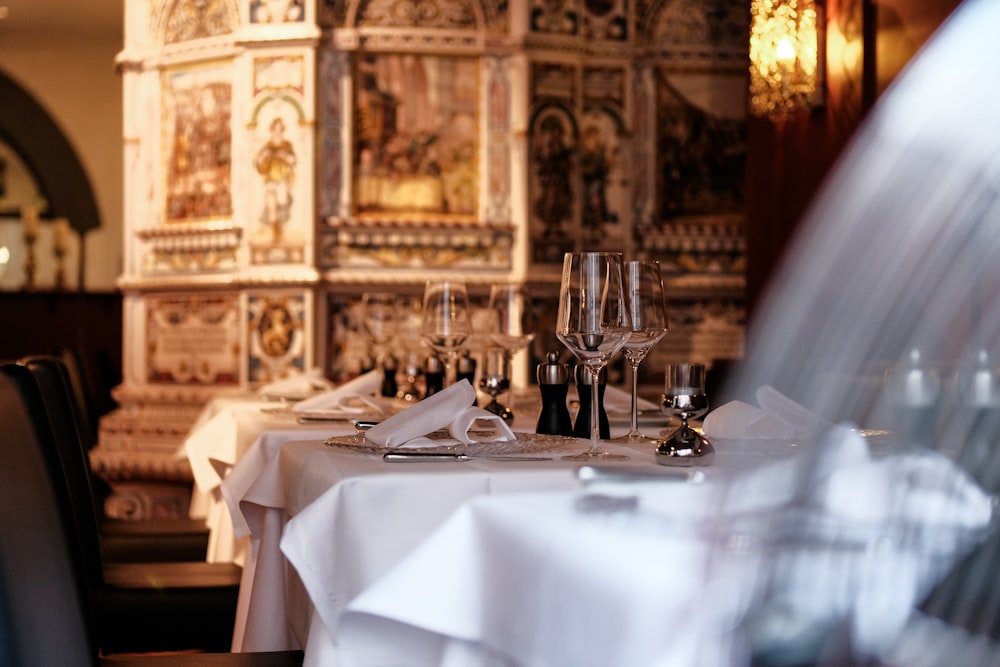 a table with a white table cloth and wine glasses