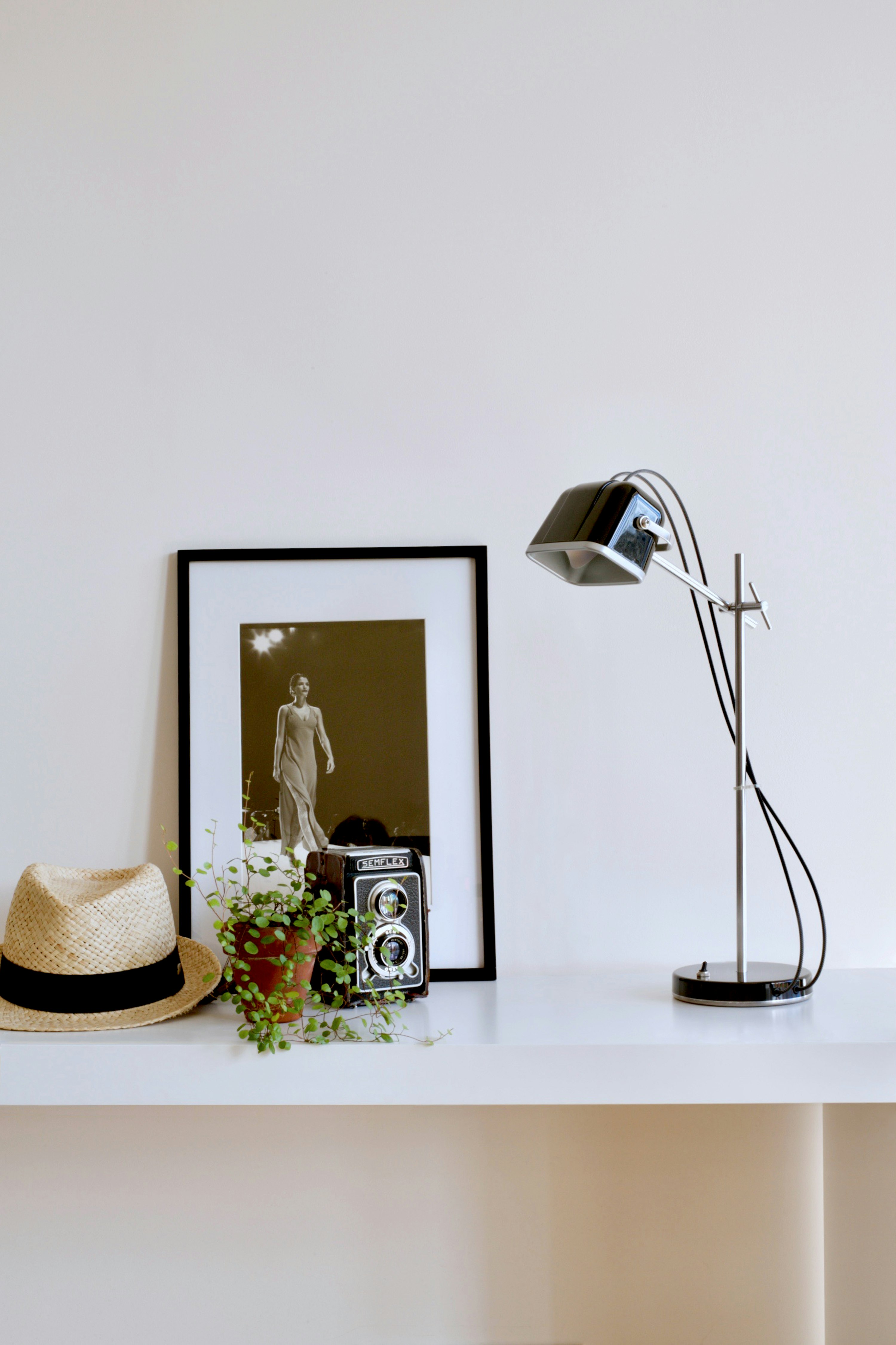 shallow focus photo of black desk lamp beside wooden frame