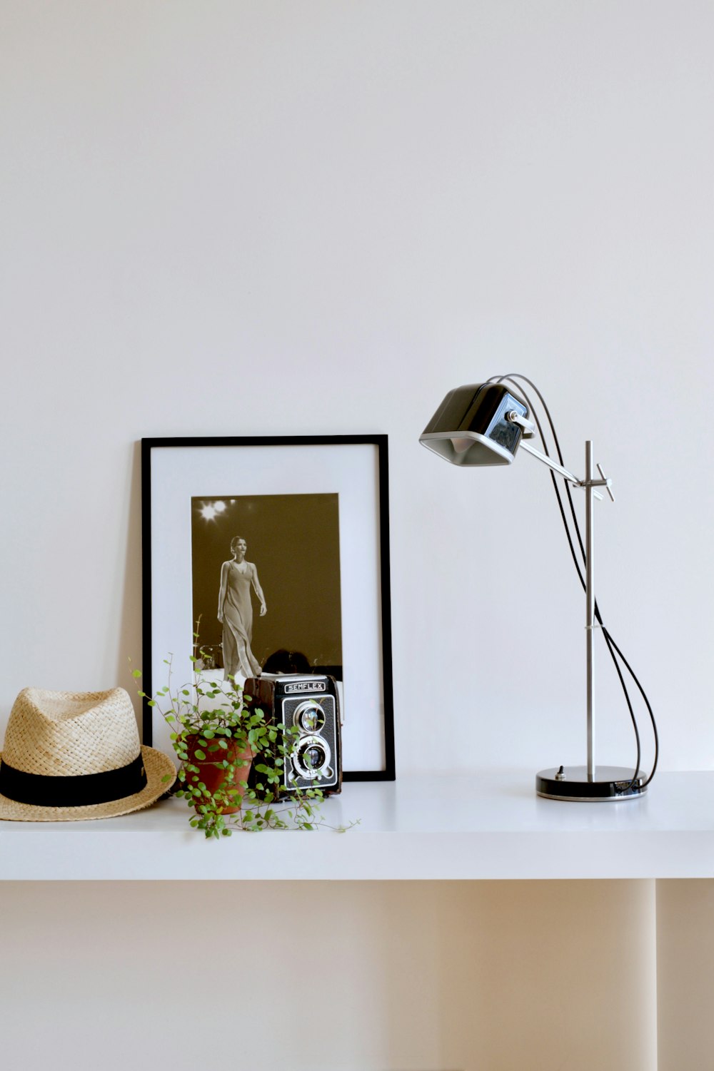 shallow focus photo of black desk lamp beside wooden frame