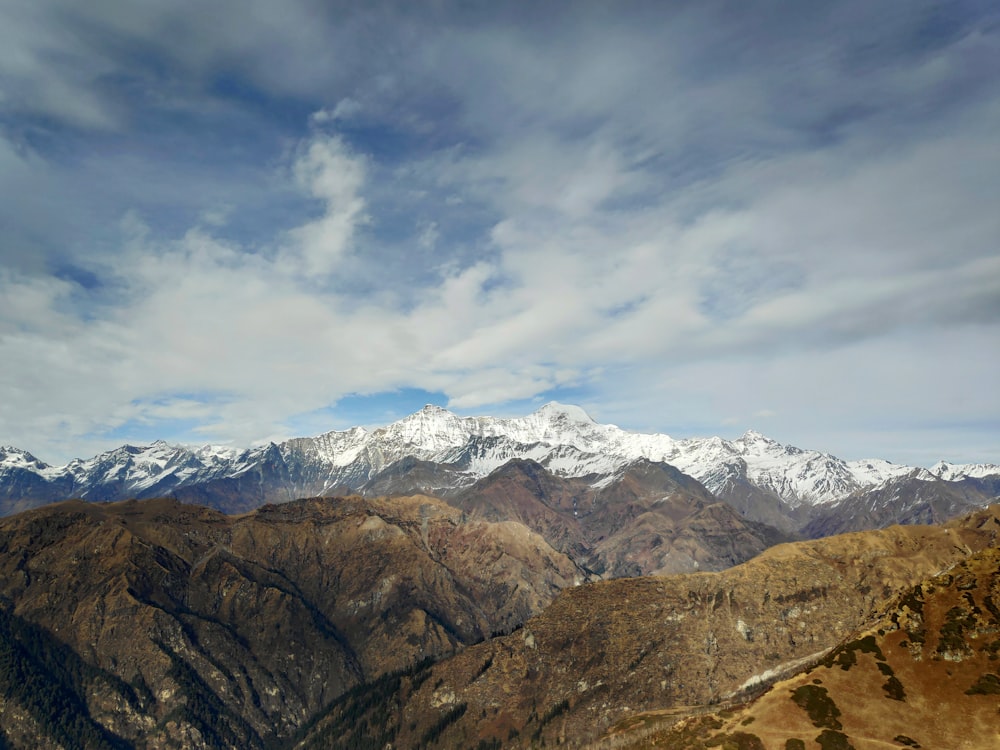 snow covered mountains under cloudy sky