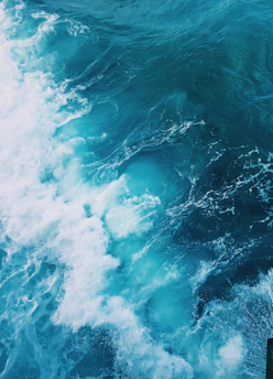 Close-up of a vibrant ocean art piece made with epoxy resin, capturing swirling blue and white waves.