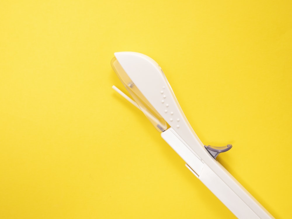 white plastic ornament on yellow surface