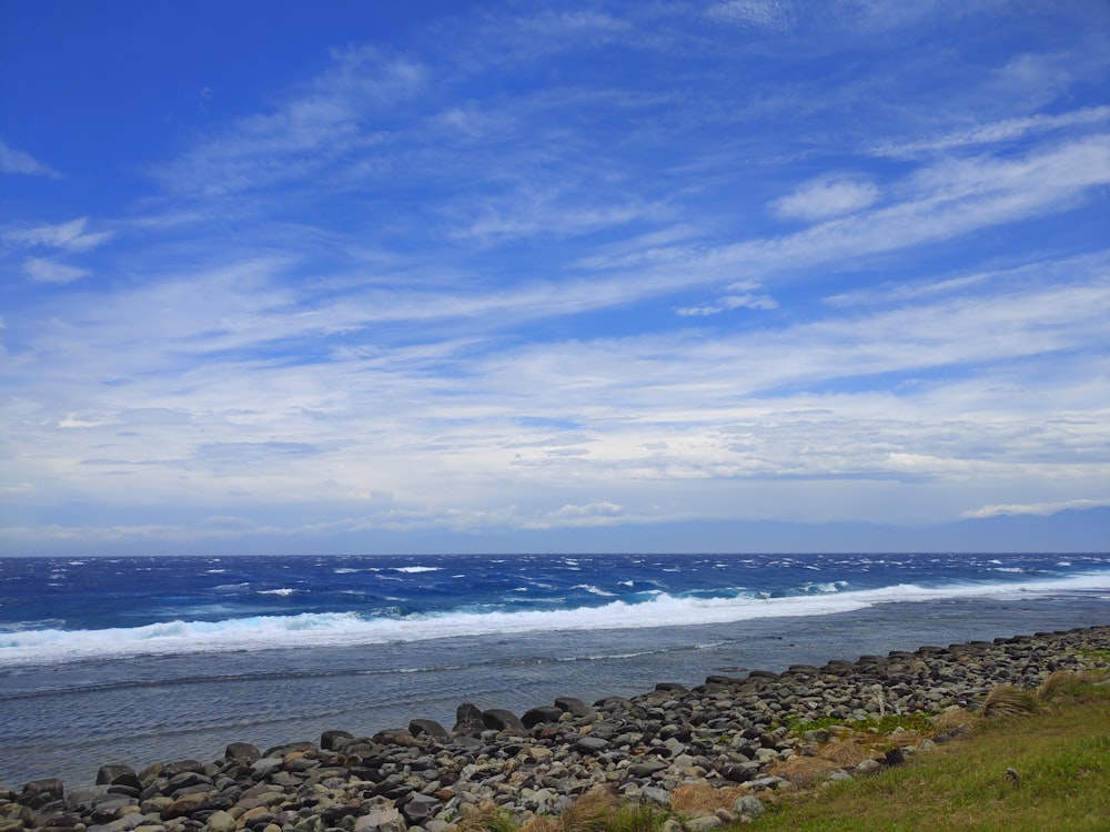 a man riding a surfboard on top of a rocky beach