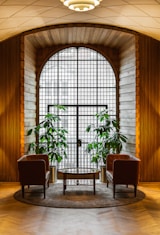 two chairs and a table in front of a large window