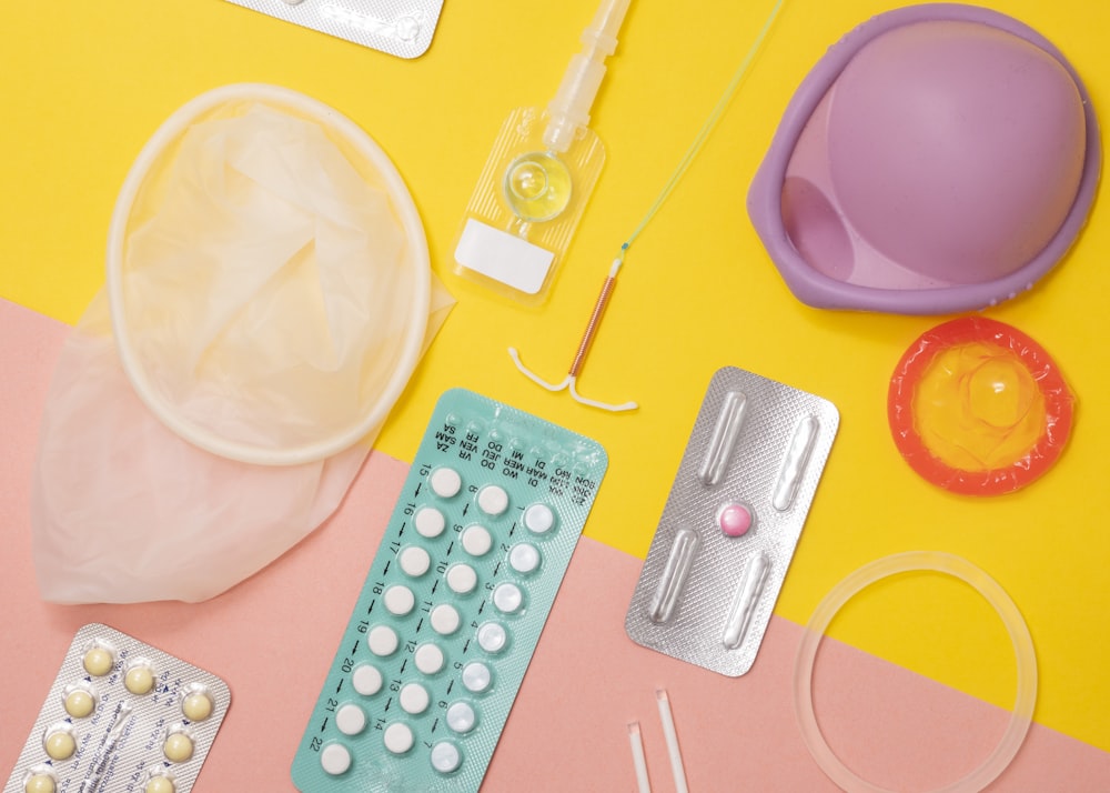 A variety of contraceptives: birth control pills, vaginal ring, intrauterine device, and arm implant.