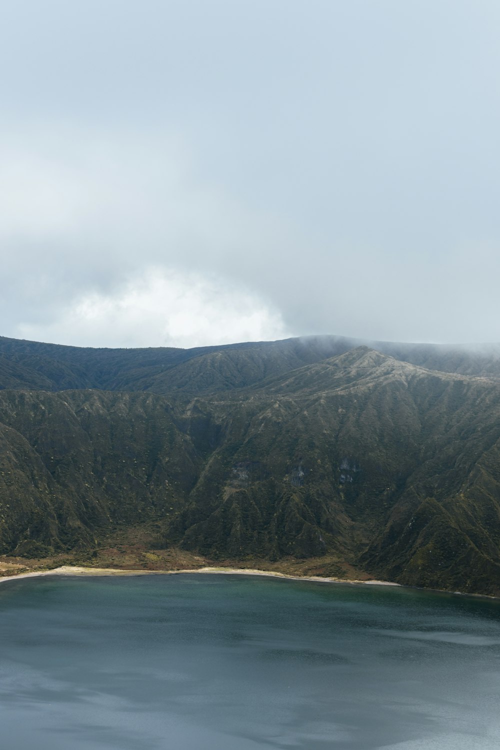 Landschaftsfotografie von Bergen in der Nähe eines Gewässers
