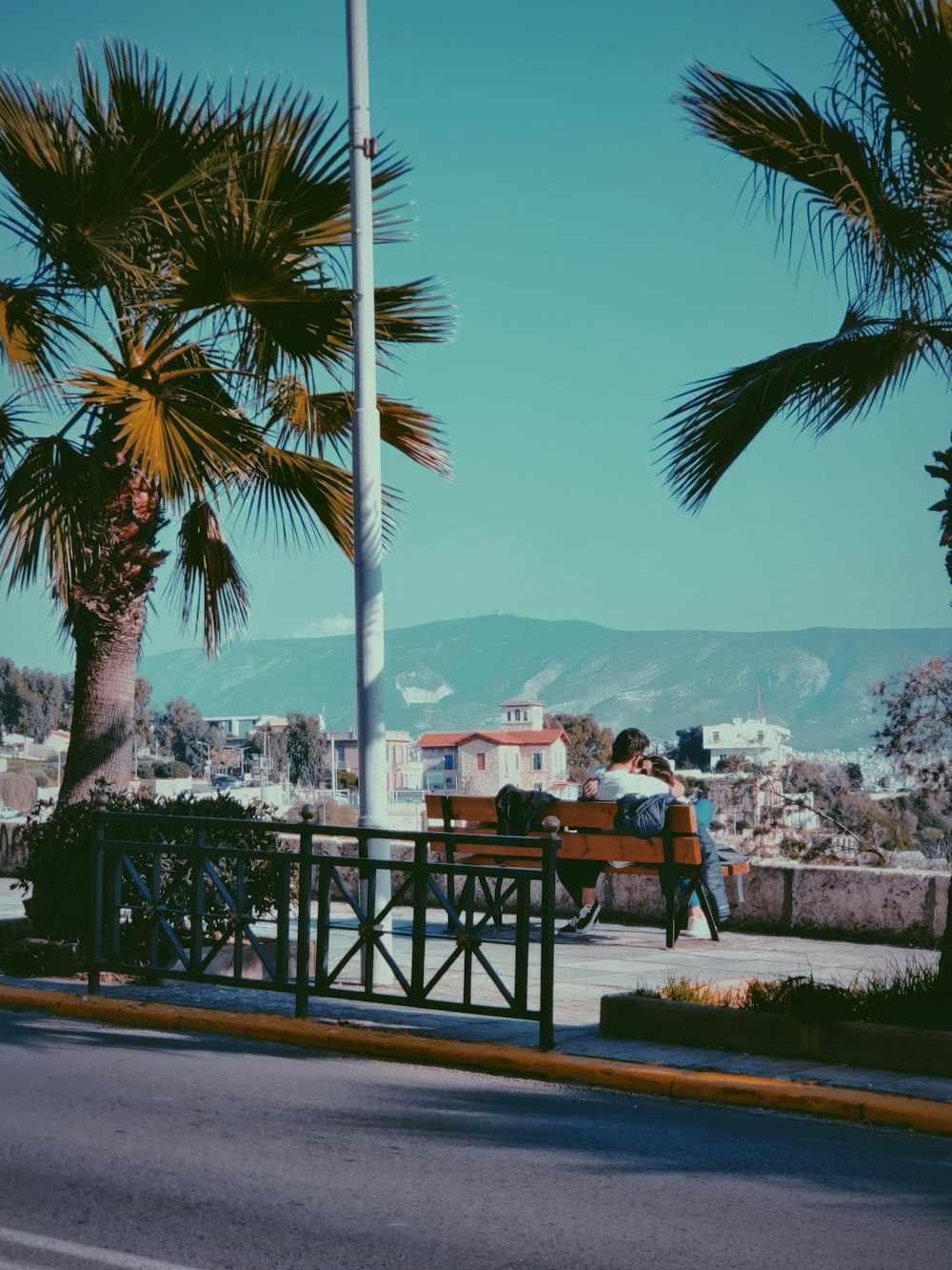 man and woman on bench near road