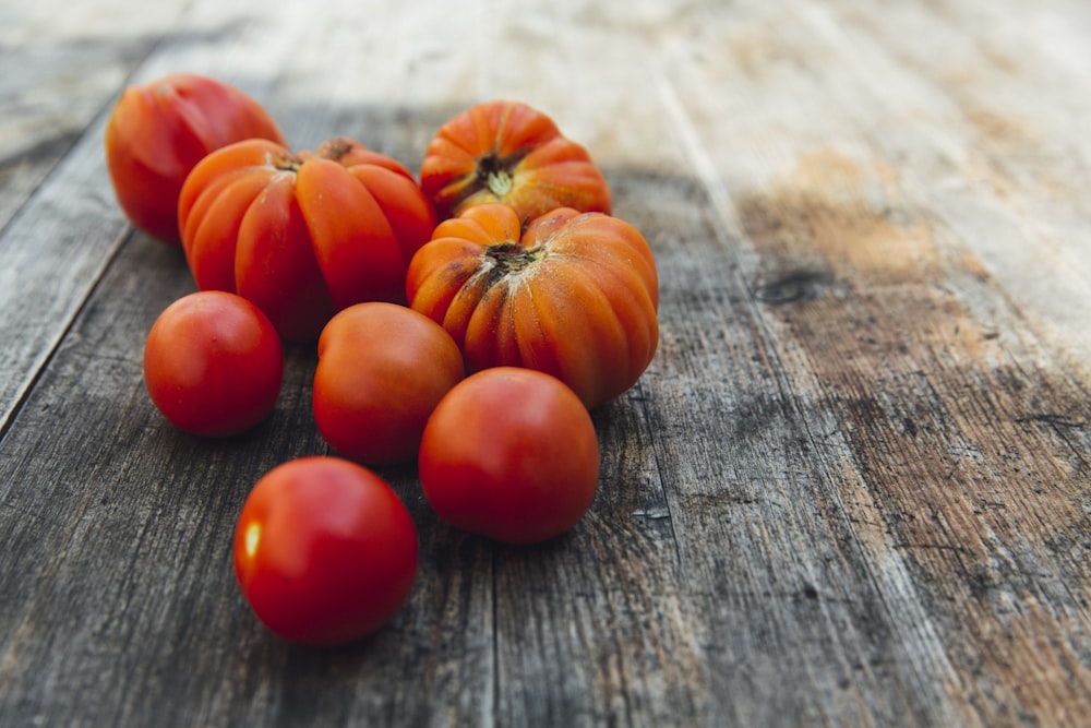 red tomatoes on wooden surface