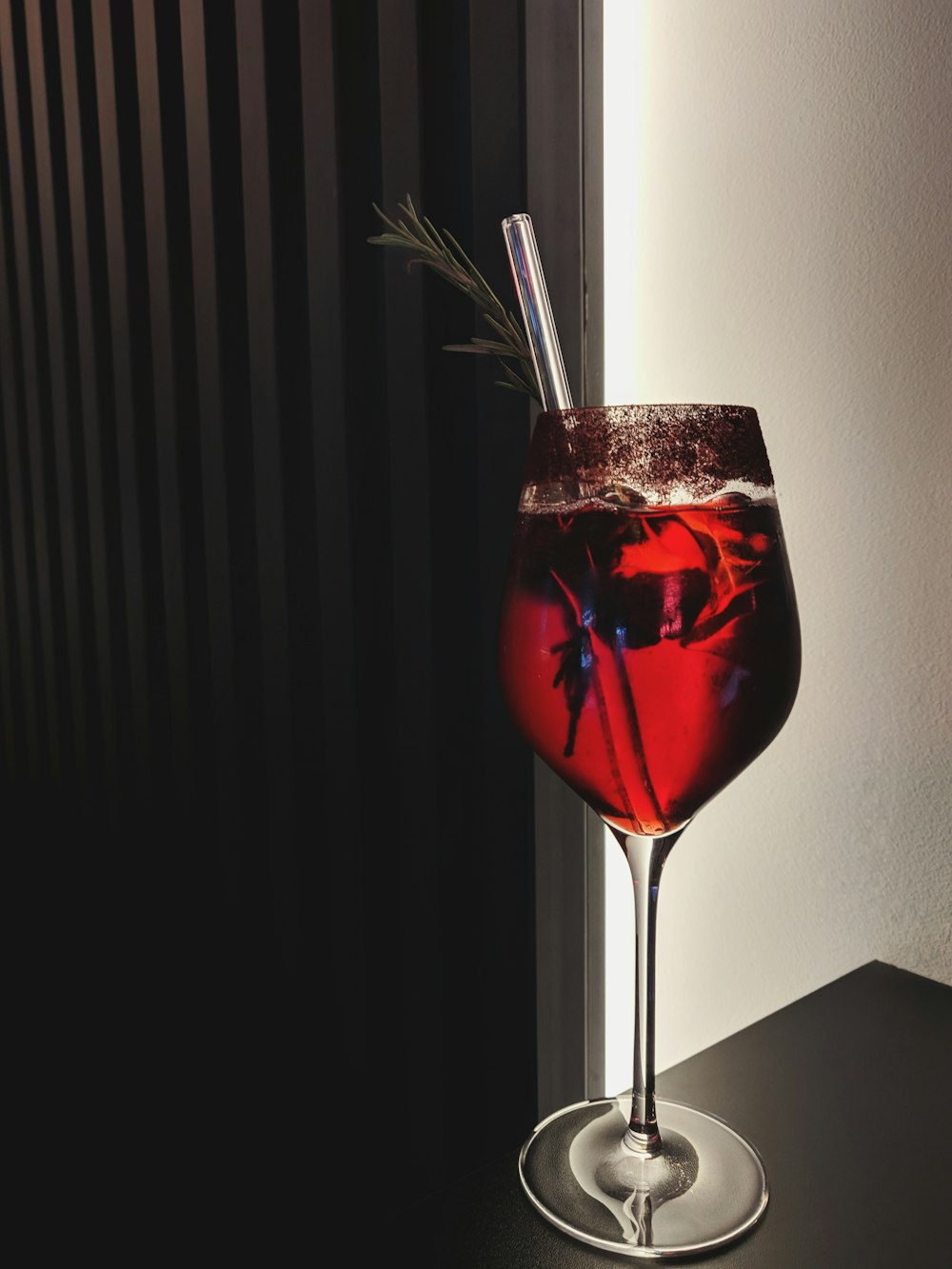 red liquid filled long-stem glass cup on table top