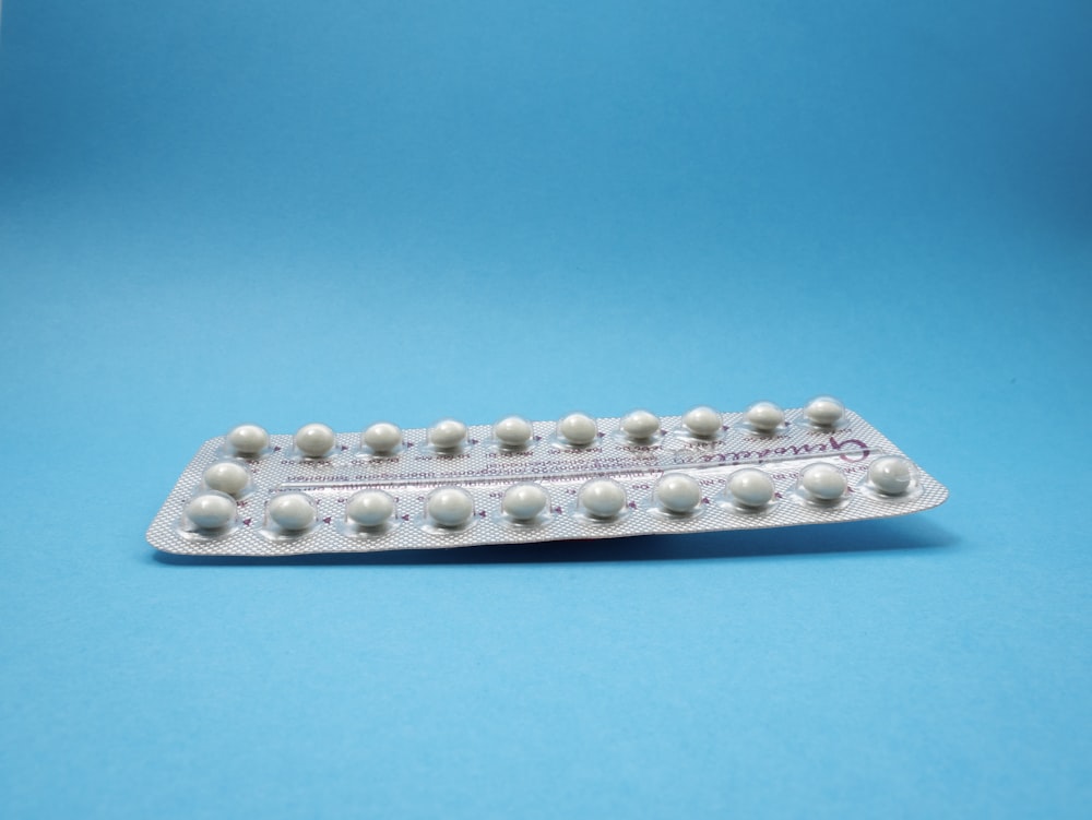 Pille zur oralen Kontrazeptiva auf blauem Panel