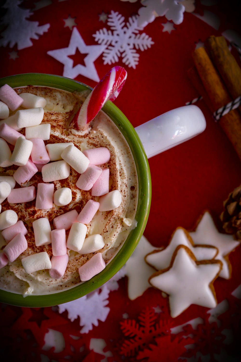 ice cream with marshmallow and candy can in green and white ceramic mug