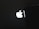 A bright, illuminated logo resembling an apple with a bite taken out of it is prominently displayed against a dark background, partially obscured by an object on the right side.