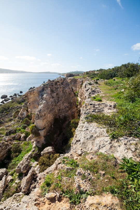 cliff viewing blue sea under blue and white sky in L'Ahrax Malta