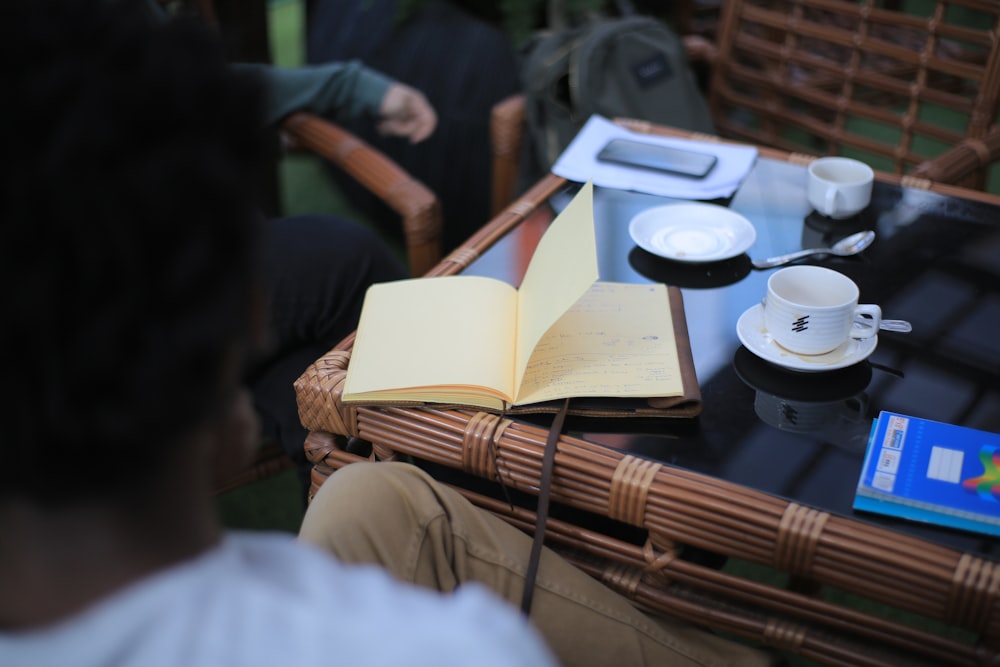 book beside coffee with saucer on table