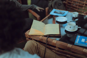 A cozy setting with a couple and officiant chatting over coffee, surrounded by wedding planning notes.