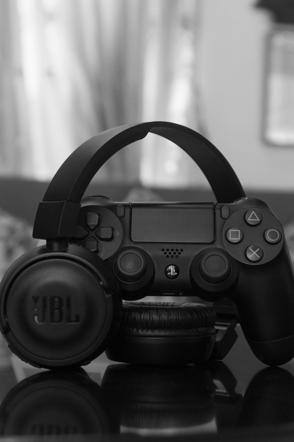 Sony PS DualShock 4 neben kabellosen JBL-Kopfhörern