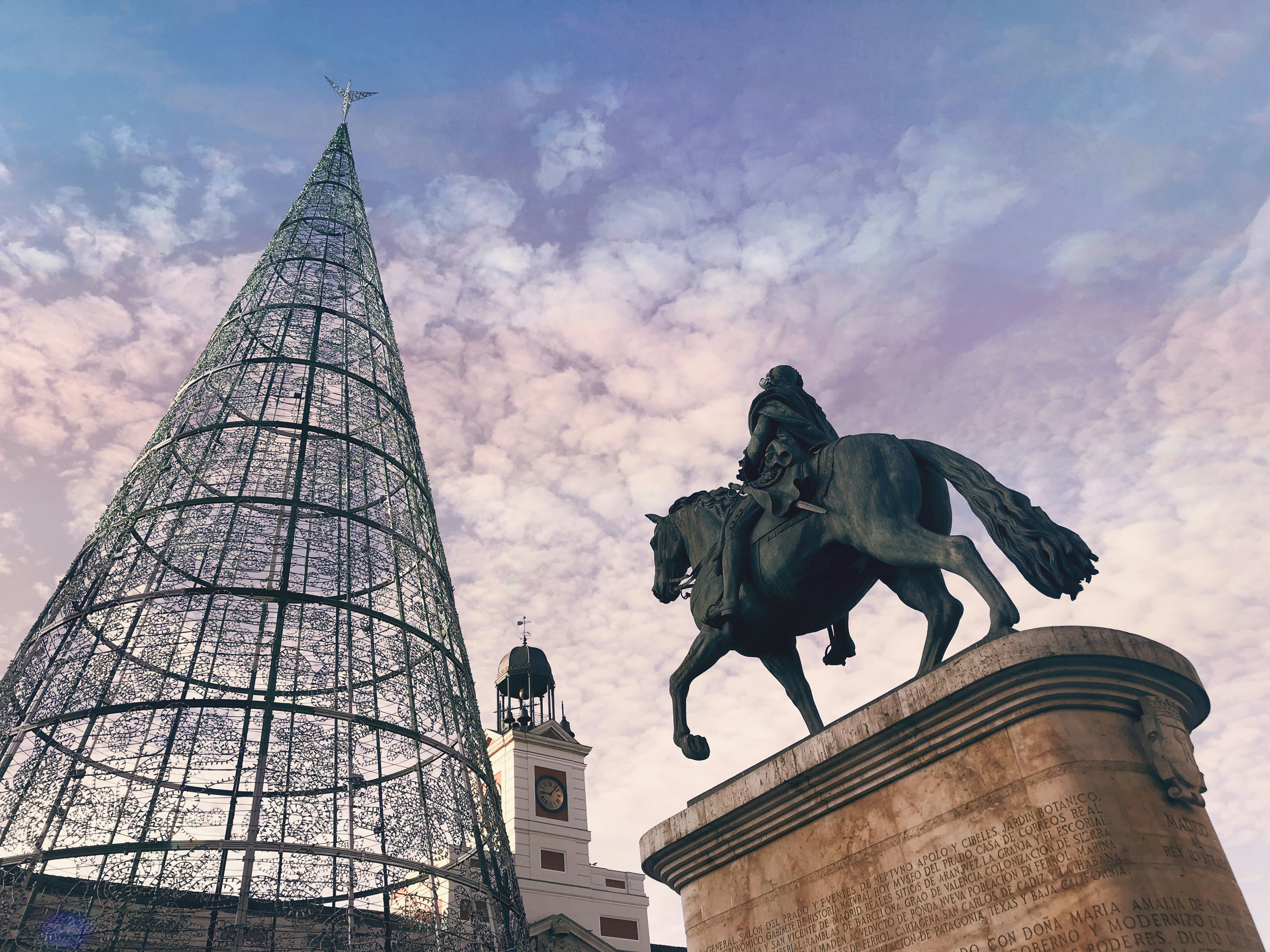 man riding on horse statue near building